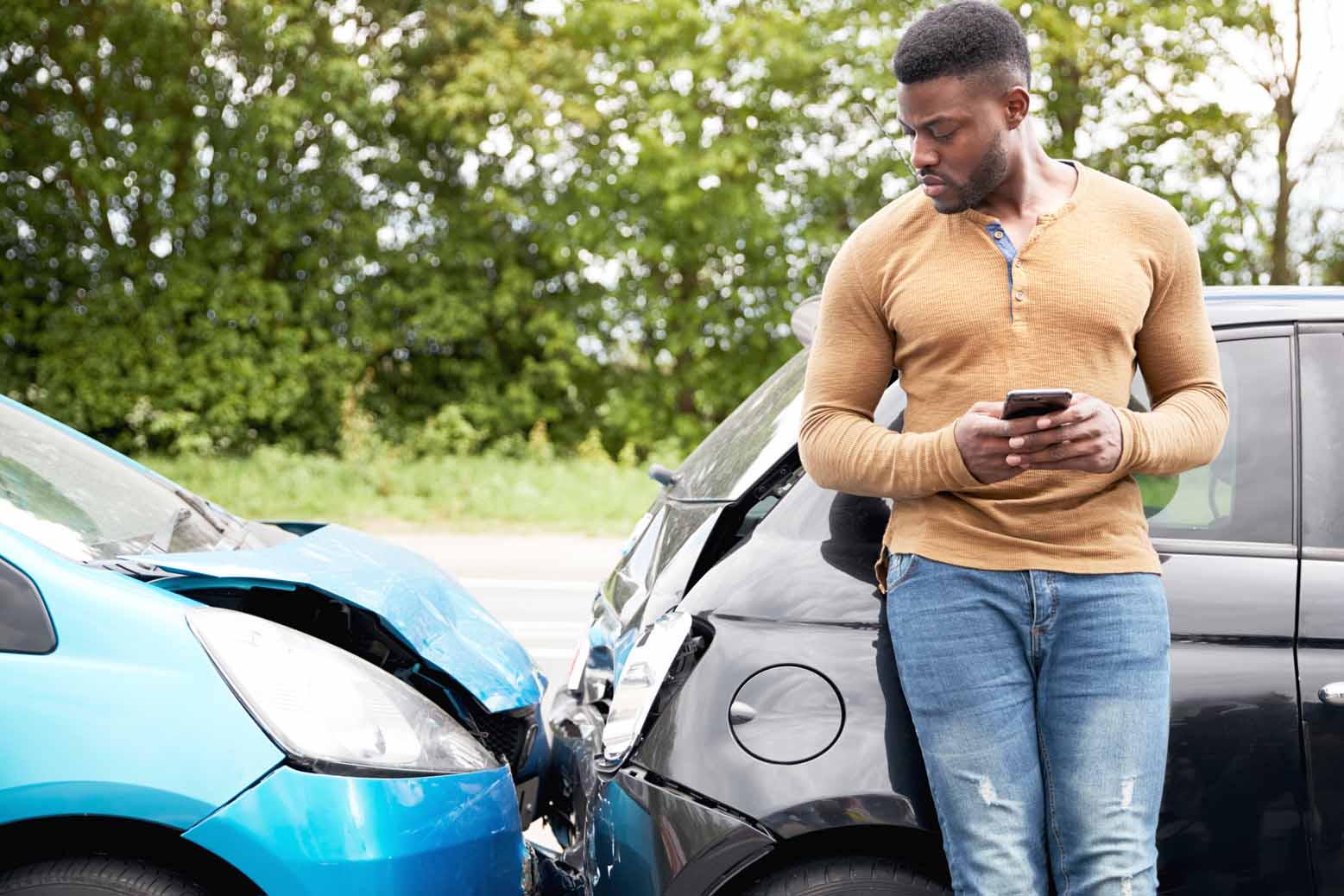 Male driver inspects damage to his car after an accident.