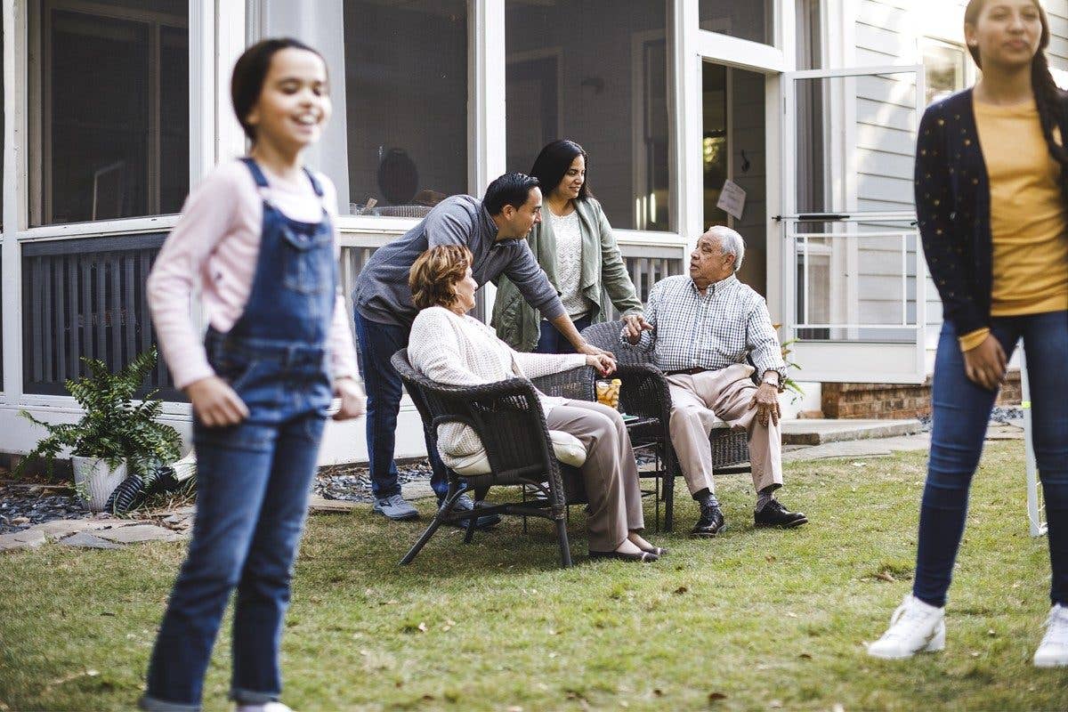 Family playing in yard and sitting in lawn furniture 