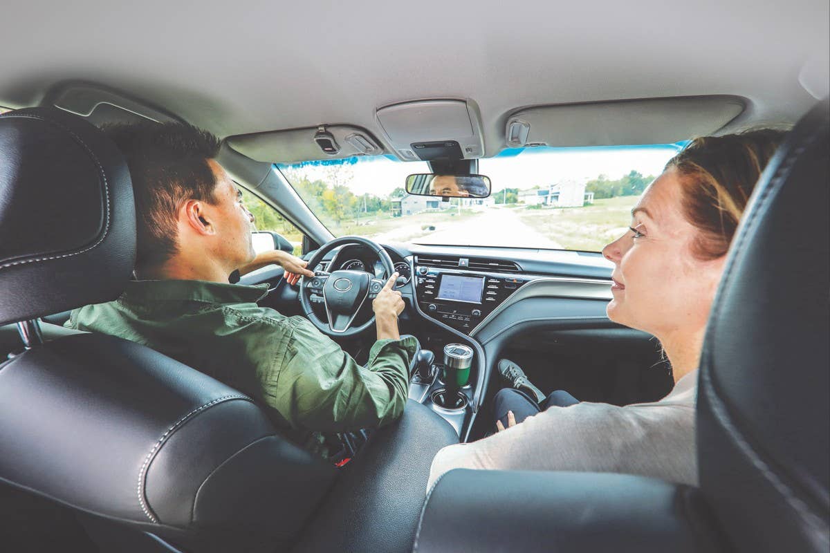 Couple talking while driving in a new car.