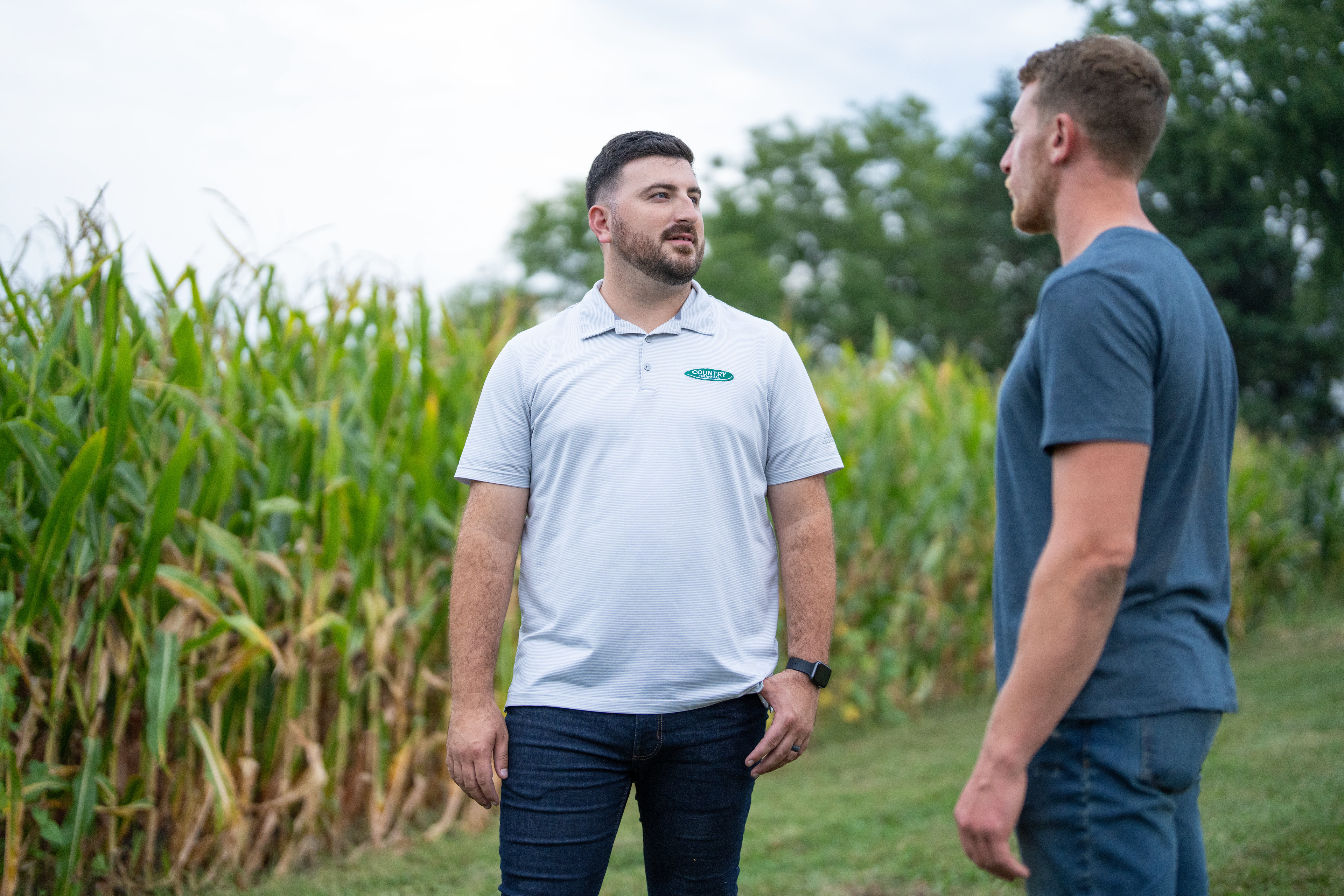 COUNTRY Financial rep meeting with farmer in front of cornfield