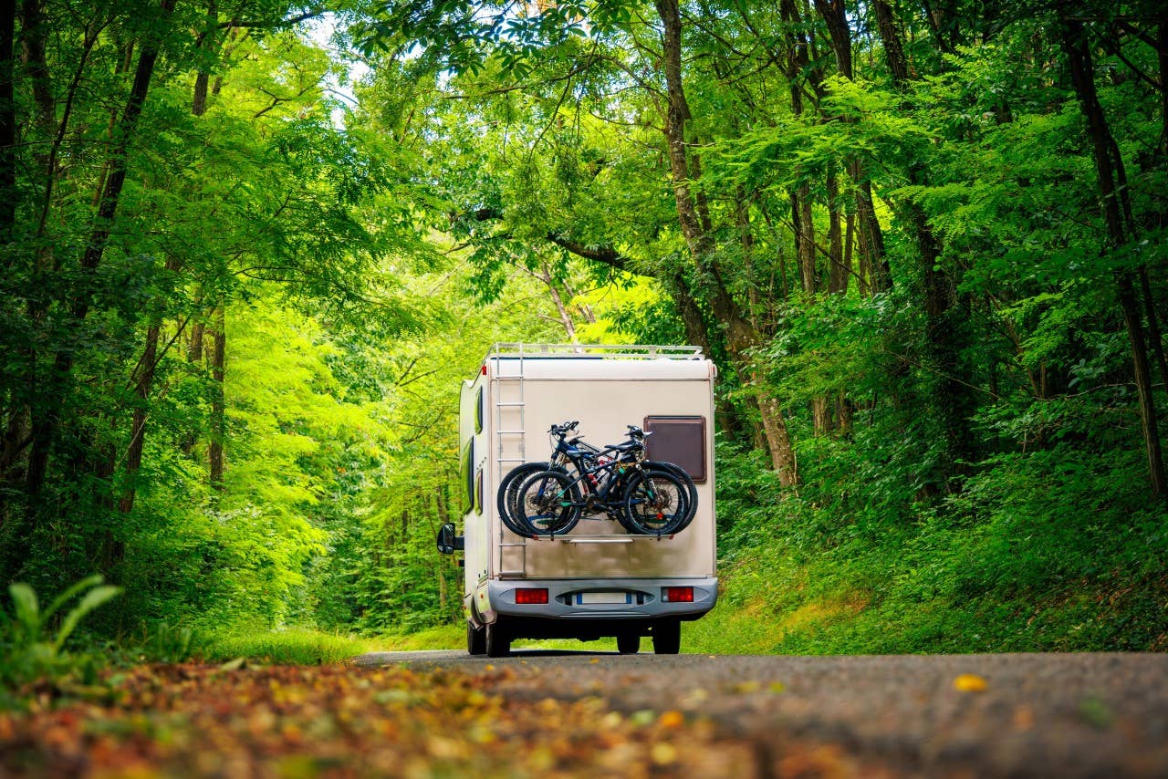 Motor home driving down the road in the forest