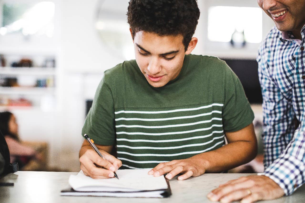 Father and son reviewing college savings at table