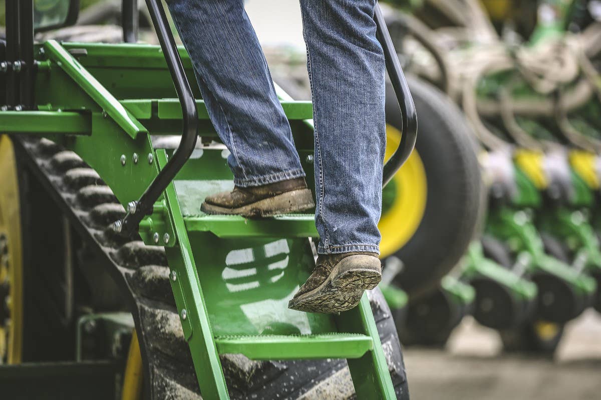 Farmer stepping up tractor steps